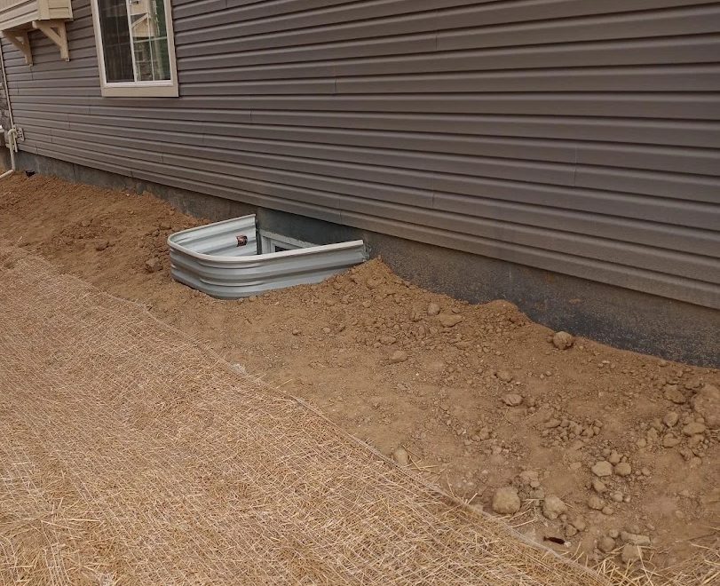 Galvanized egress window well installed at the foundation of a new build