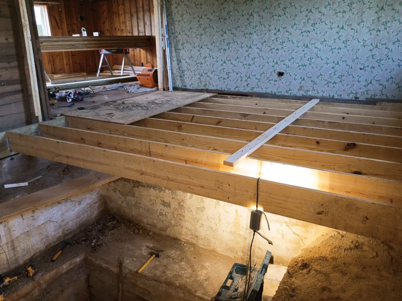 New floor joist framing spanning an excavated crawlspace
