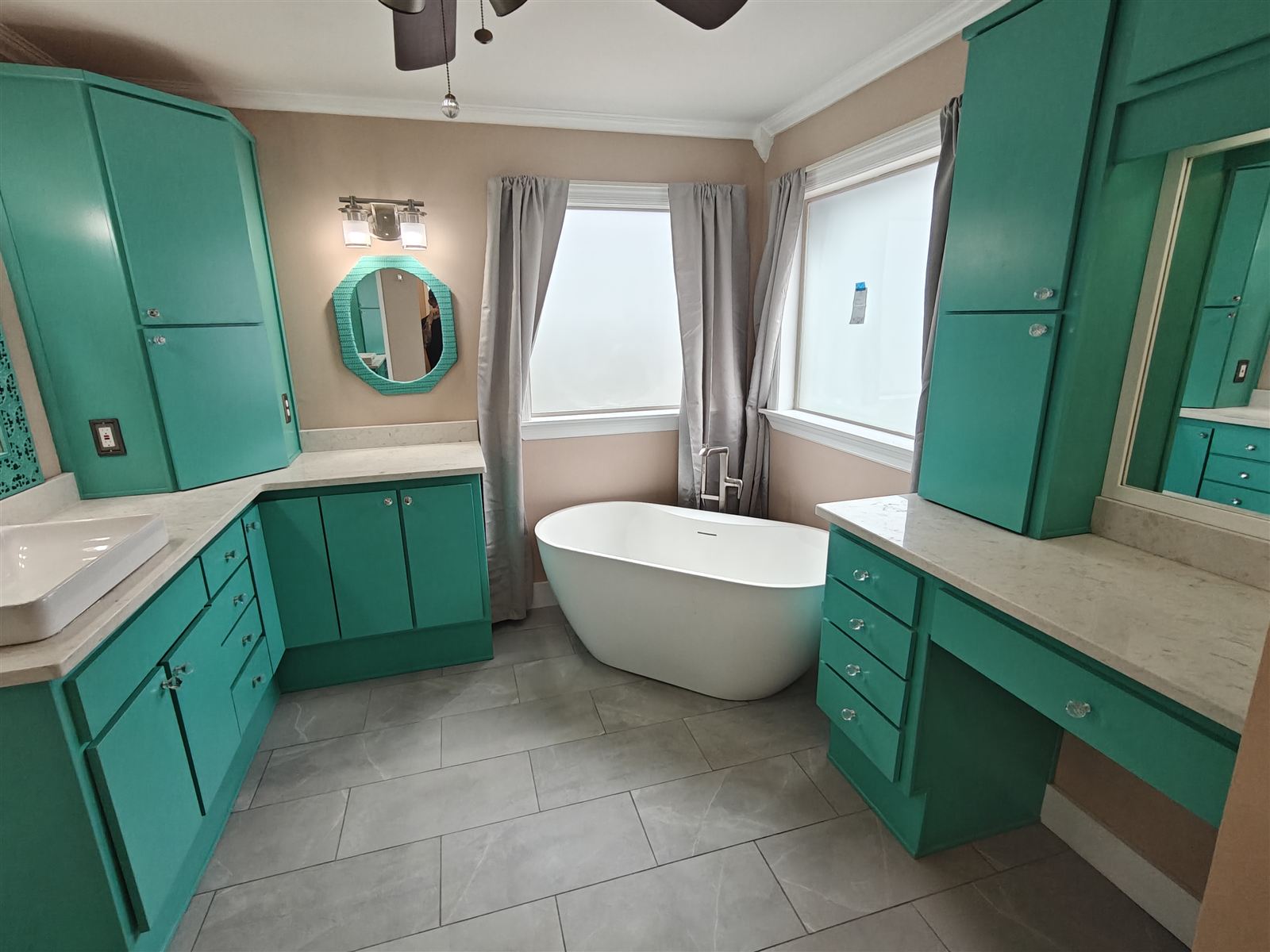 Bathroom remodel with teal vanity, quartz counters and freestanding tub